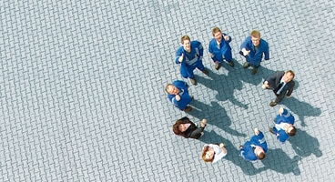 Birdview of people in different working-clothes standing in a circle